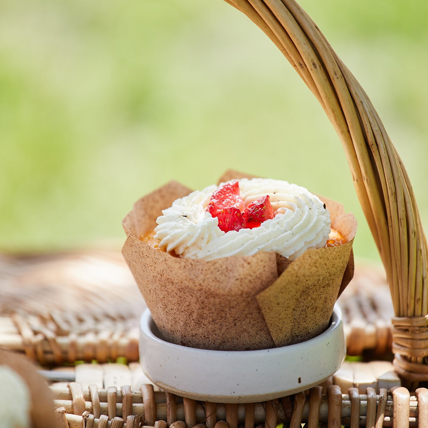 Erdbeercupcake auf einem Picknickkorb